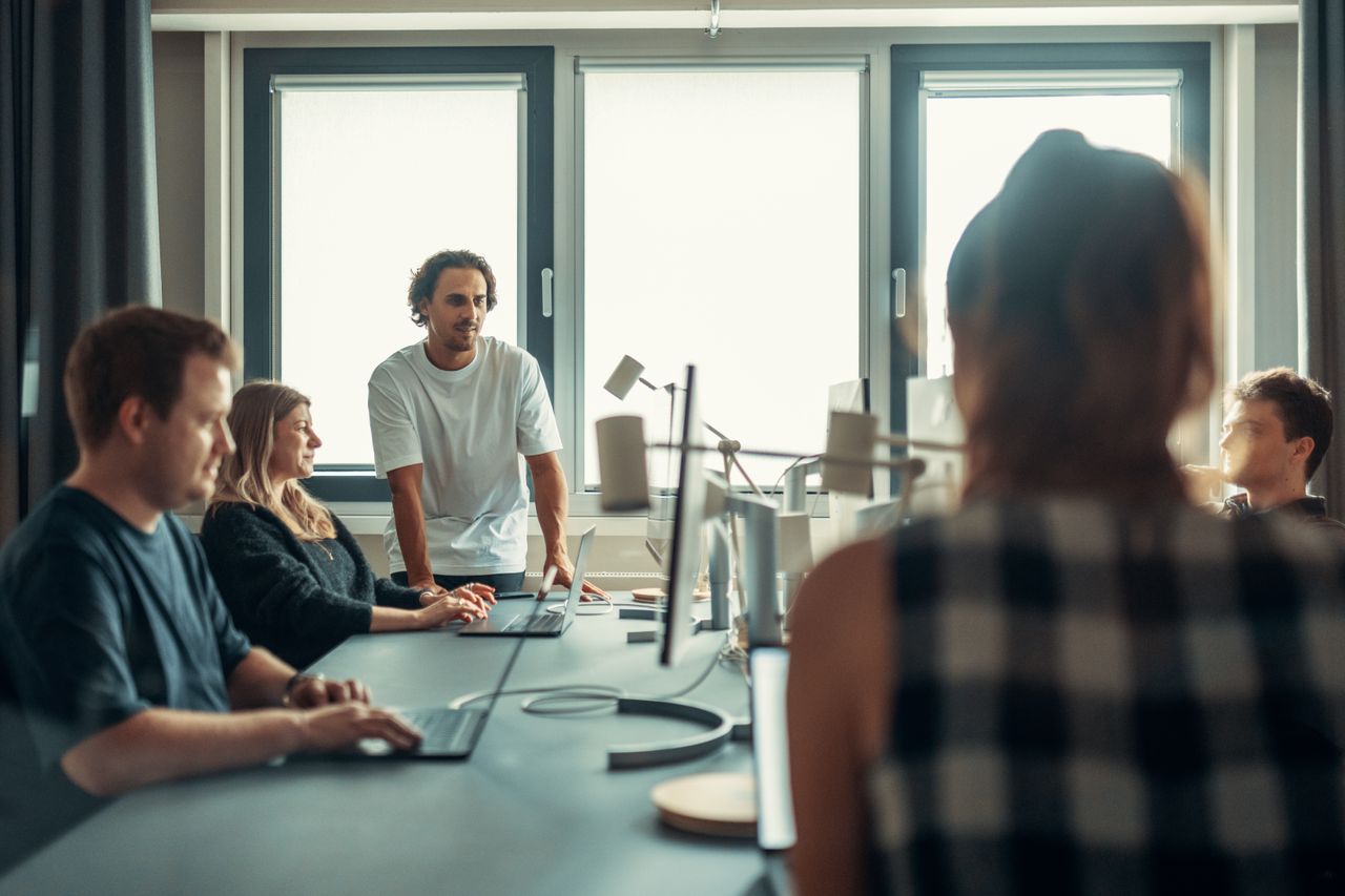 Une équipe variée échange activement lors d’une réunion collaborative au bureau.